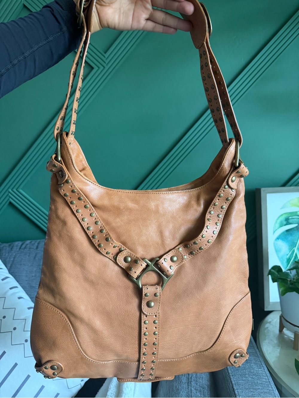 Kooba Hobo Bag features distinctive gold-tone hardware and stud detailing.